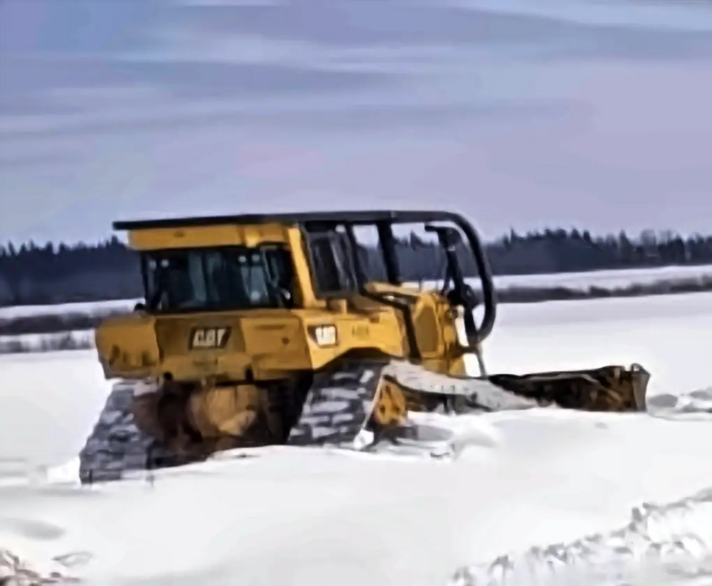CAT D6T dozer pushing snow on a winter job in Saskatchewan