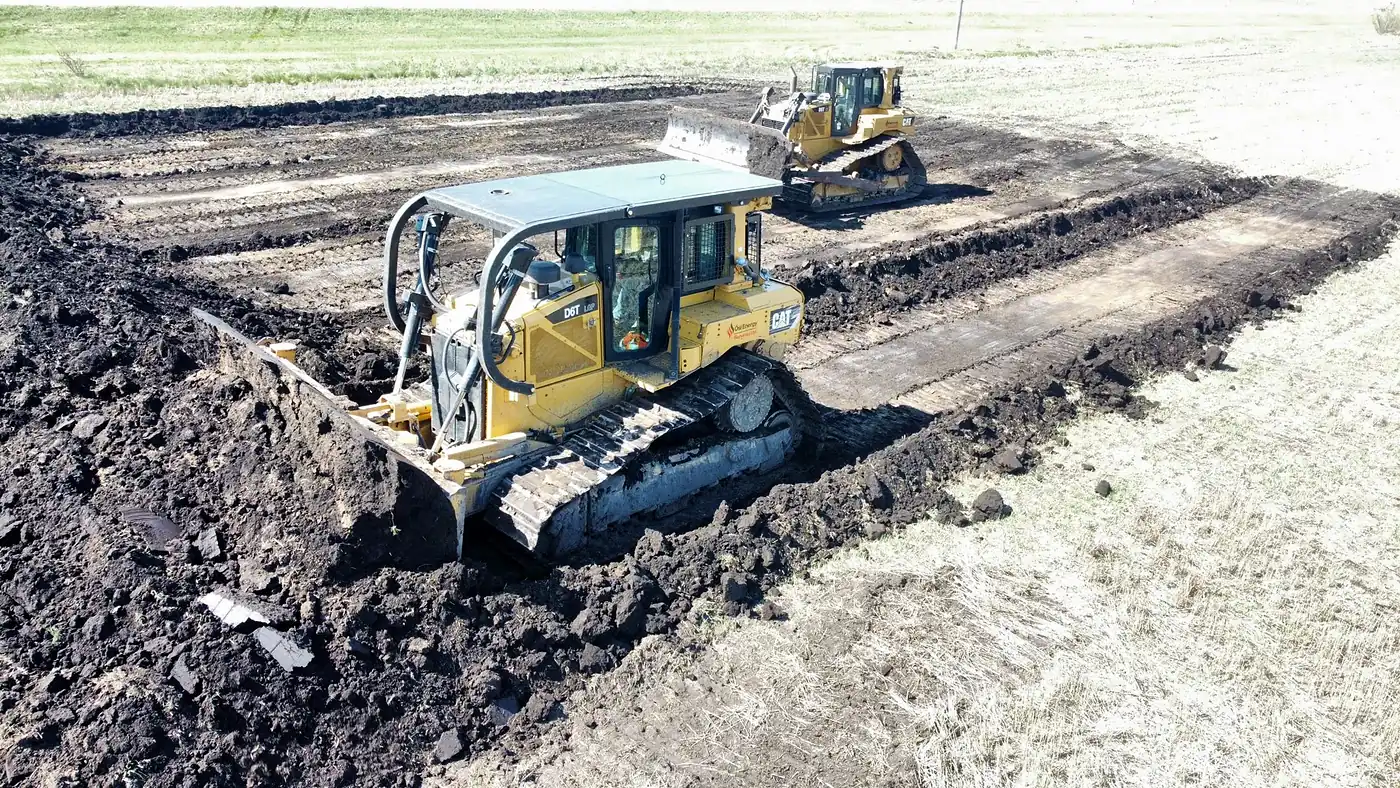Two CAT D6T dozers stripping topsoil on a site preparation job in Saskatchewan