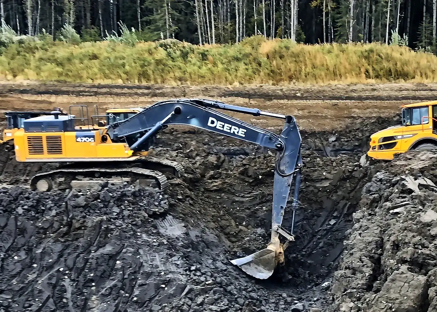 Deere excavator digging a deep excavation for an emergency repair