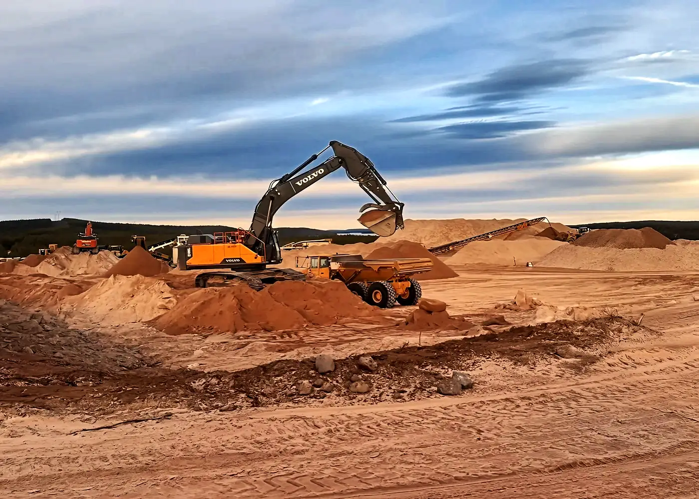 Excavator working a gravel pit in Saskatchewan at dusk