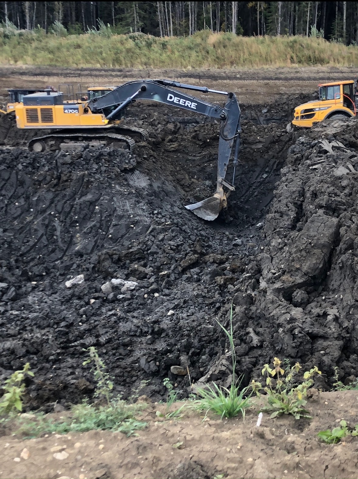 Deere excavator in mass excavation cut