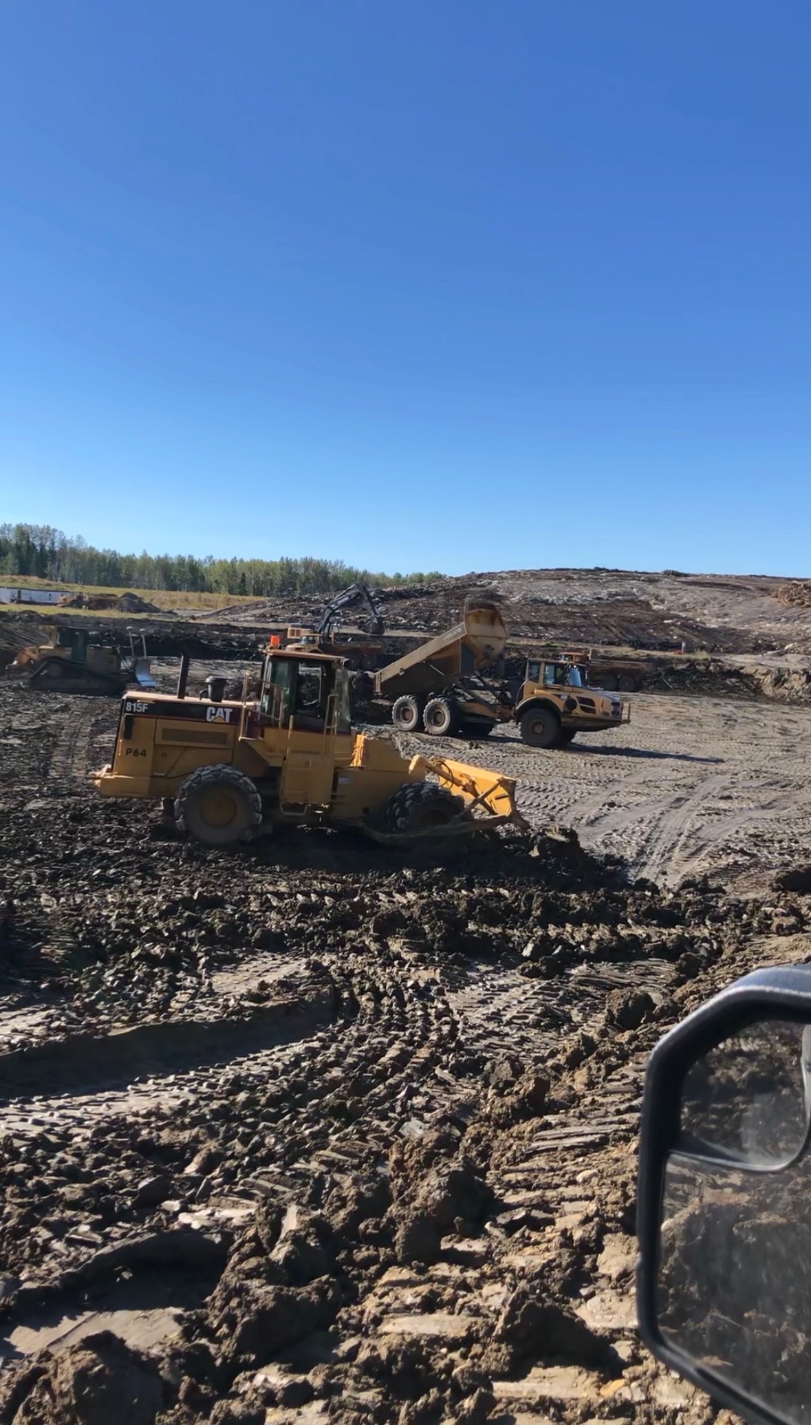 CAT compactor and haul truck on open site