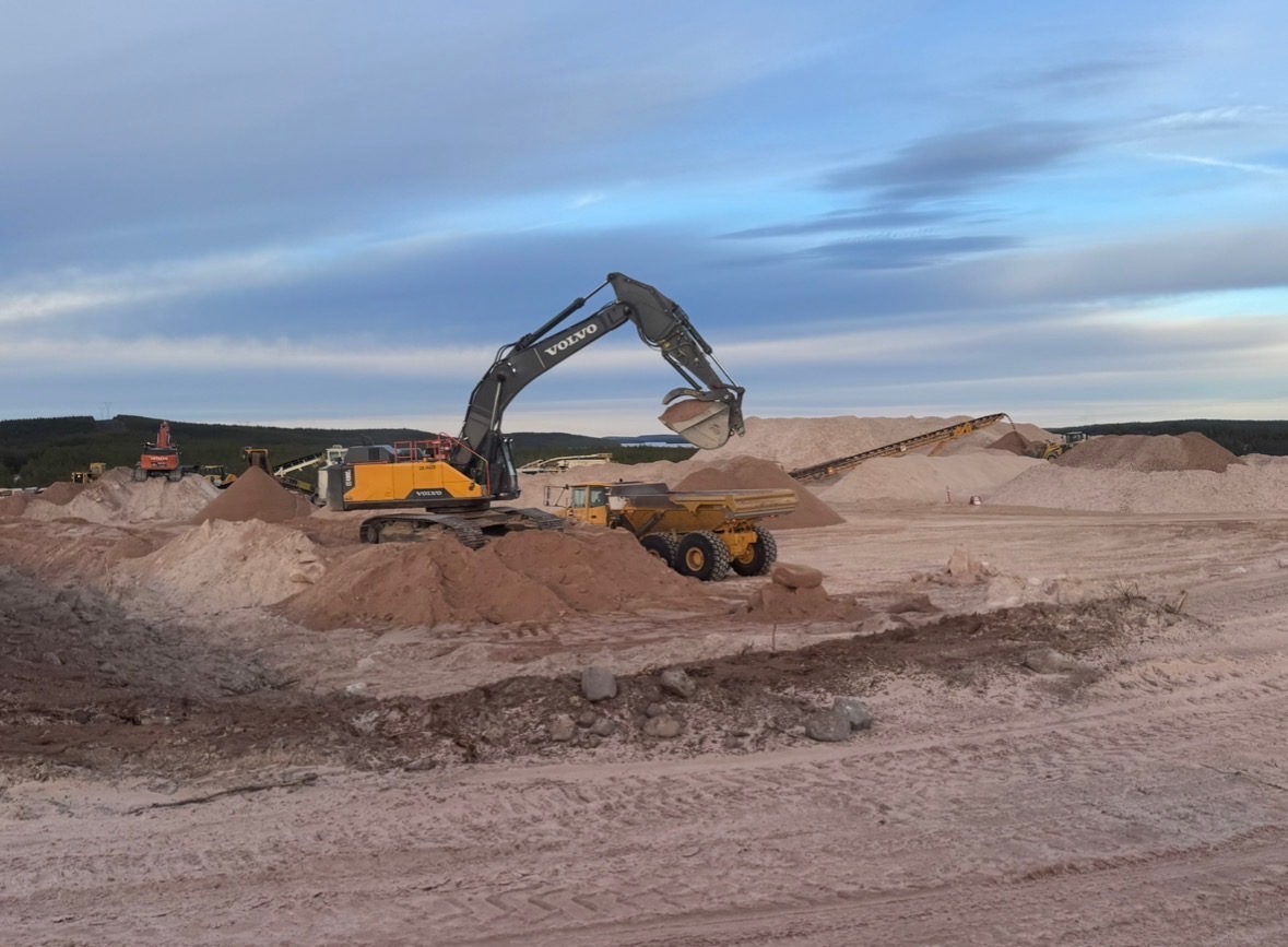 Volvo excavator loading haul truck at gravel pit