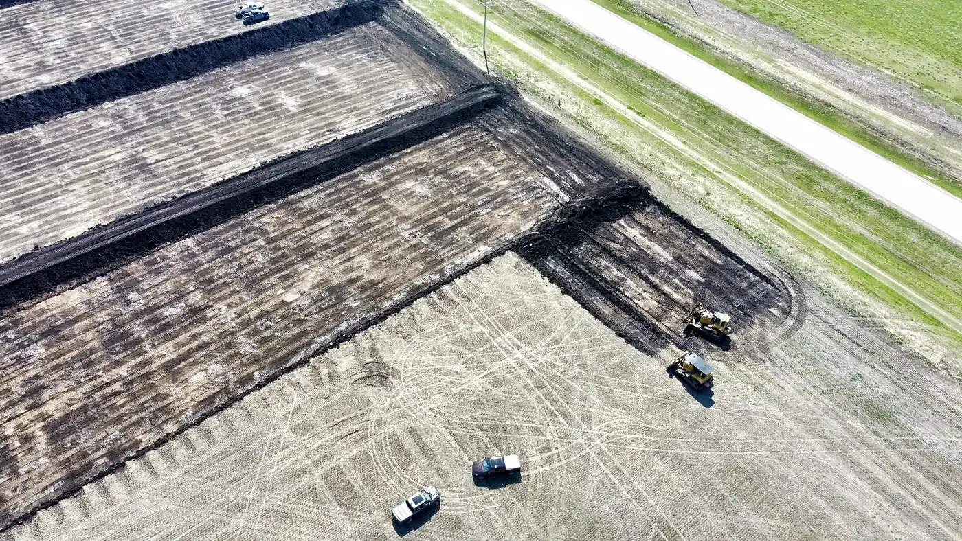 Aerial view of dozers stripping topsoil inside a marked site footprint